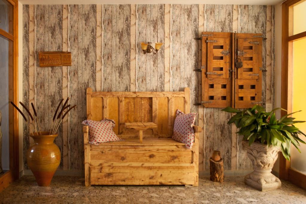 a room with a wooden wall with a bench and pillows at Apartamentos rurales La posada de Donato in Nuévalos