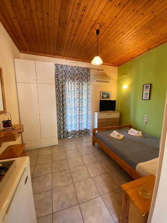 a bedroom with a bed and a television in a room at MARATHES STUDIOS in Agios Nikitas