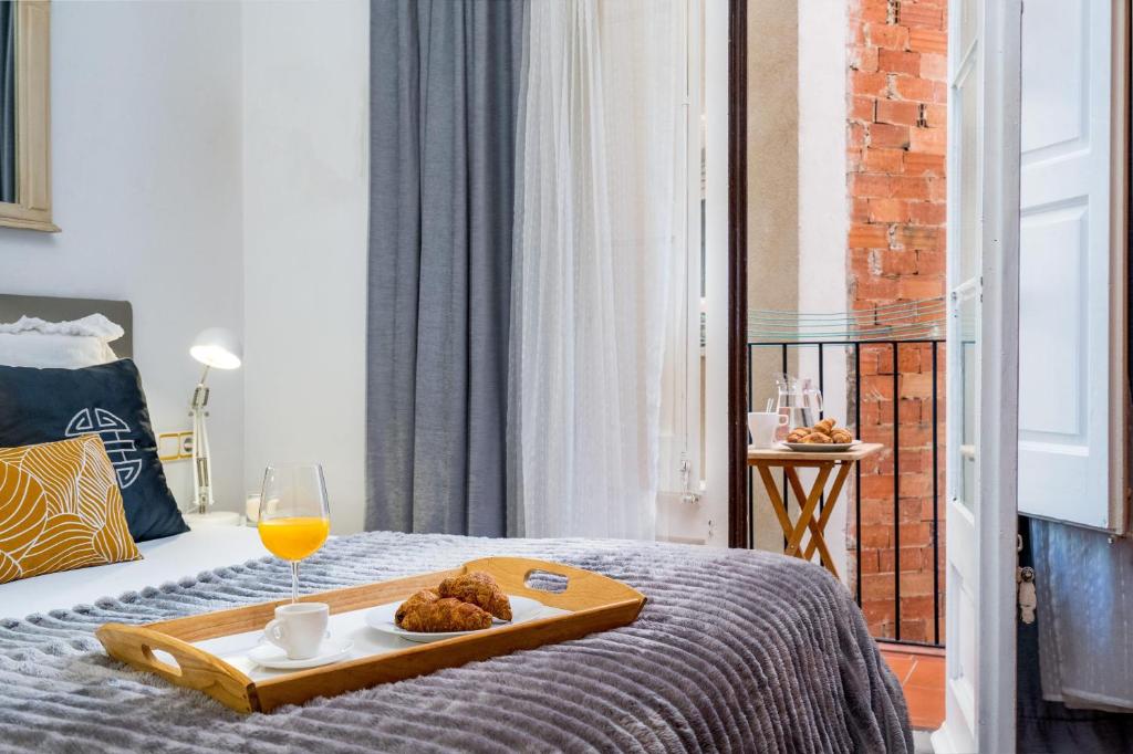 una habitación de hotel con una bandeja de comida en una cama en Whisper-quiet Near Sagrada's Heart, en Barcelona