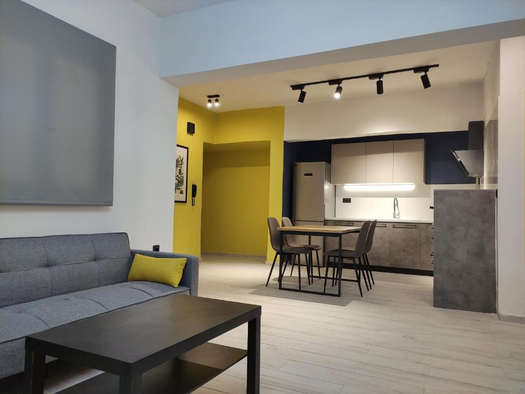 Il comprend un salon et une cuisine avec un canapé et une table. dans l'établissement Beautifull And Airy Appartment Corfu Town, à Kanoni
