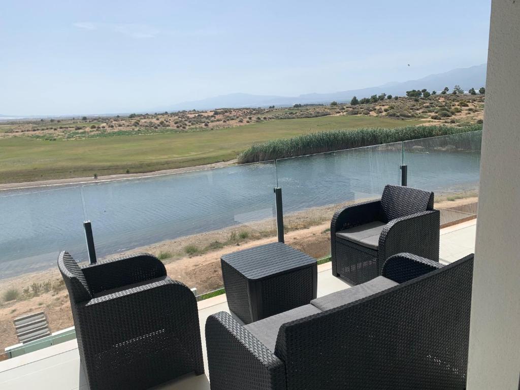 balcón con sillas y vistas al agua en Casa Kadanza, en Alhama de Murcia