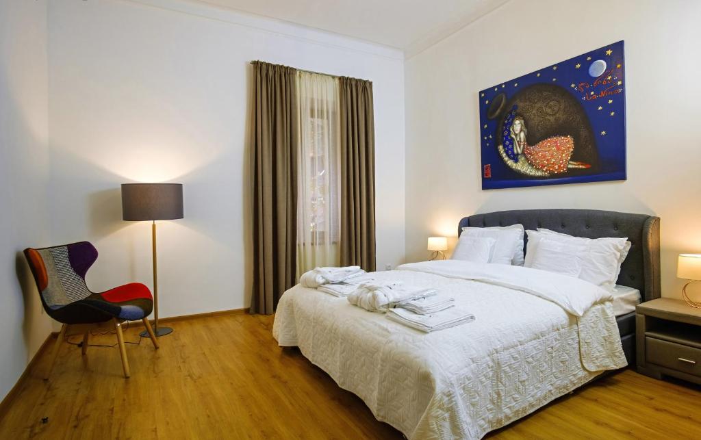 a bedroom with a bed and a red chair at BB Residence Sololaki in Tbilisi City