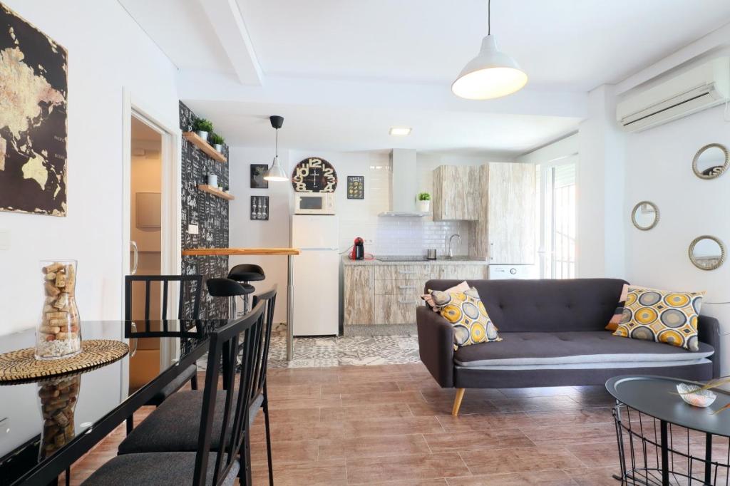 a living room with a couch and a kitchen at NEW Apartamento Tierra Andaluza junto Mezquita in Córdoba