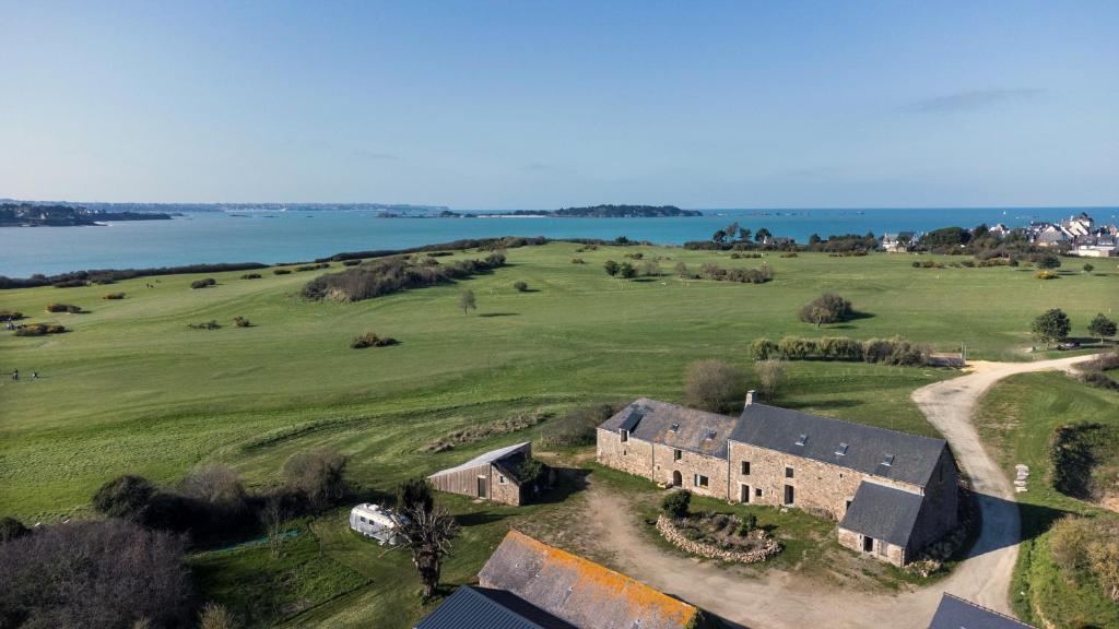 una vista aérea de una casa antigua en un campo en La Ferme du golf, gîte atypique et artistique, en Lancieux