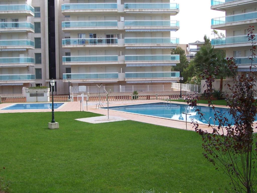 una piscina frente a un gran edificio de apartamentos en APCOSTAS - Village Park, en Salou