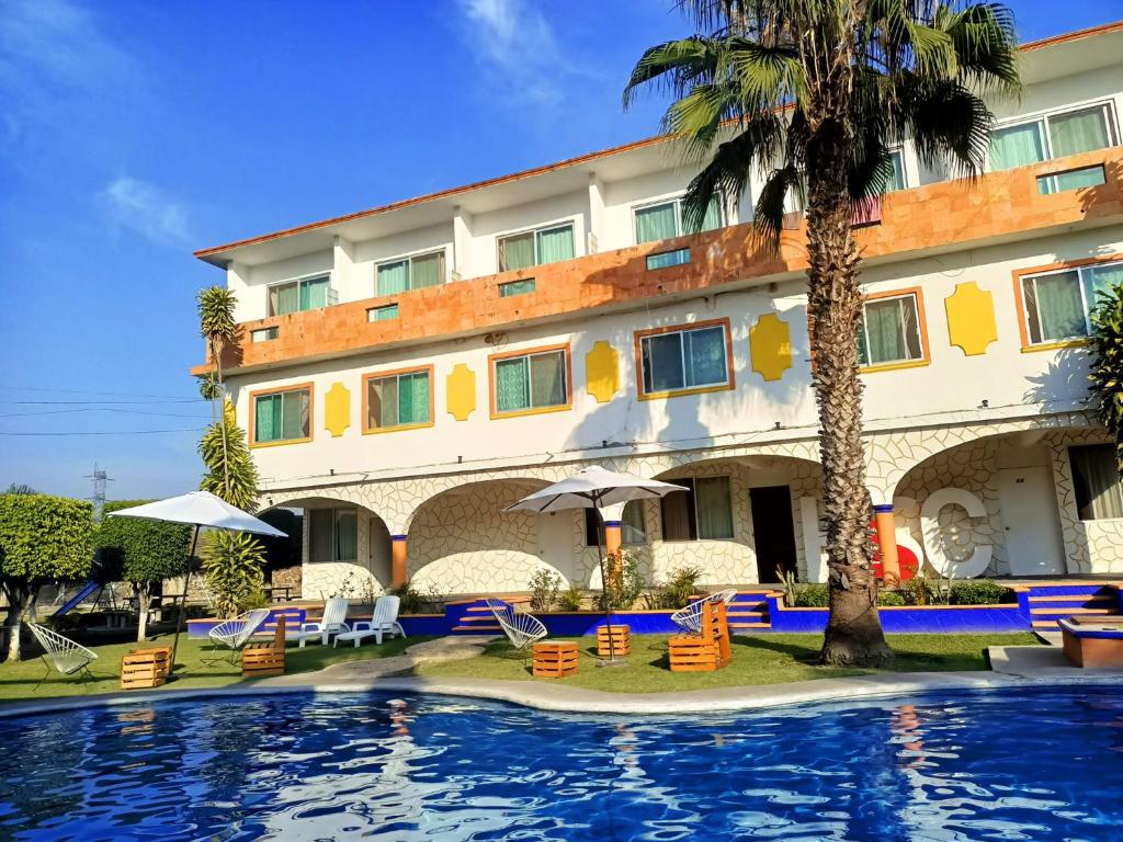 a hotel with a swimming pool in front of a building at Hotel San Carlos Yautepec in Yautepec de Zaragoza