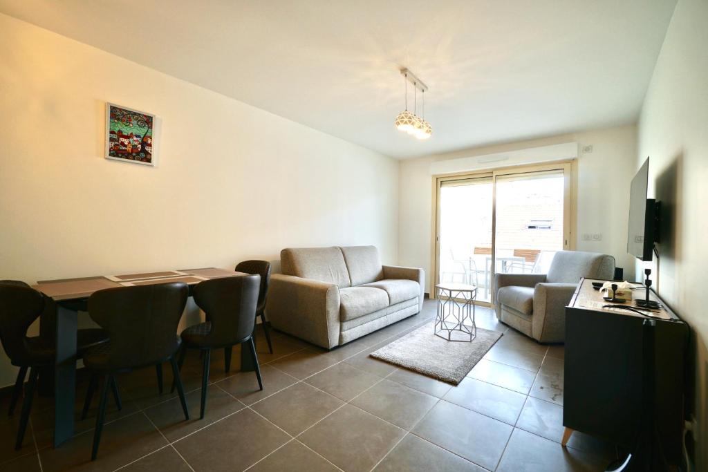 a living room with a couch and a table and chairs at Apartment Montaigne in Cannes