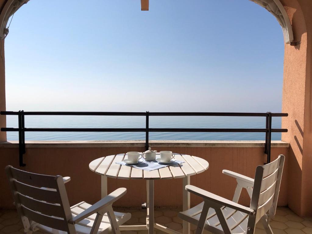 einen Tisch und Stühle auf einem Balkon mit Meerblick in der Unterkunft Condominio Fortino in Grado