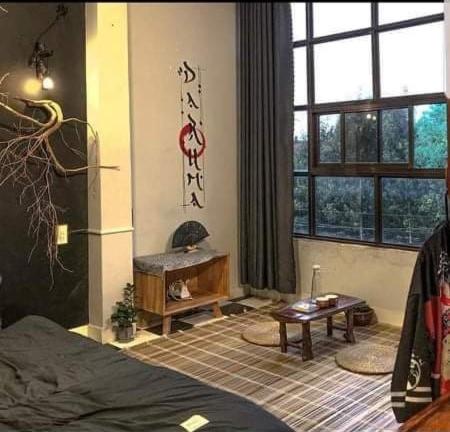 Camera con letto, tavolo e finestre di Daruma Home a Da Lat