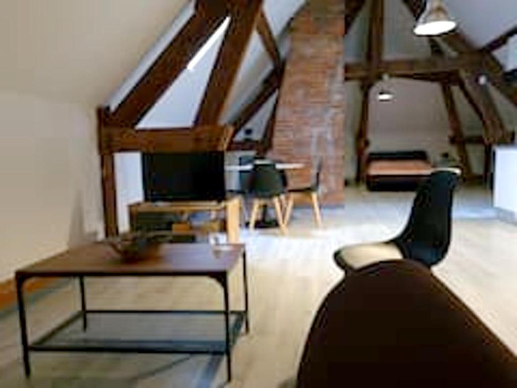 ein Wohnzimmer mit einem Sofa und einem Tisch in der Unterkunft Appartement d'une chambre avec wifi a Beaugency in Beaugency