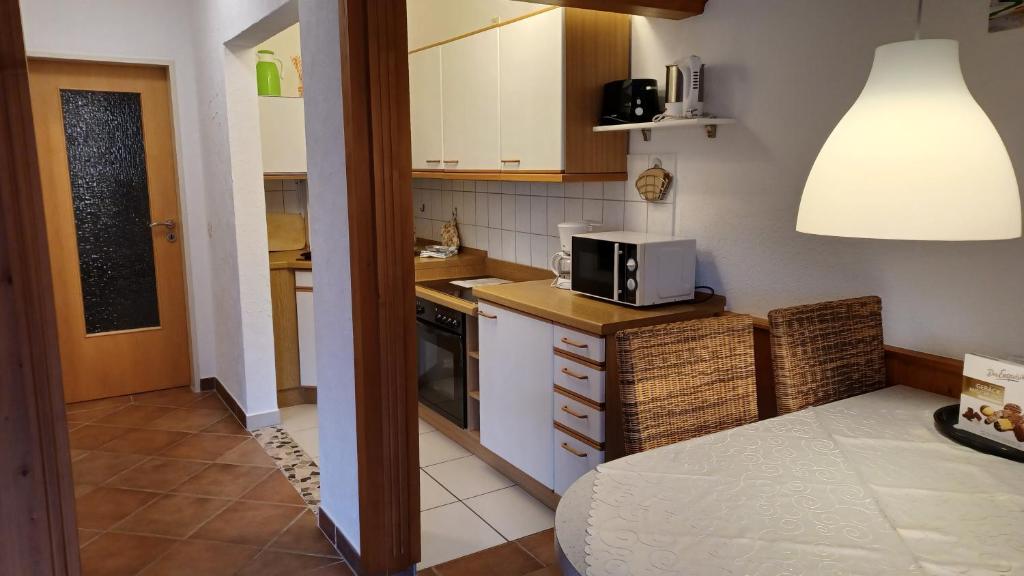 a small kitchen with a microwave on a counter at Landhaus Schlossberg in Medebach