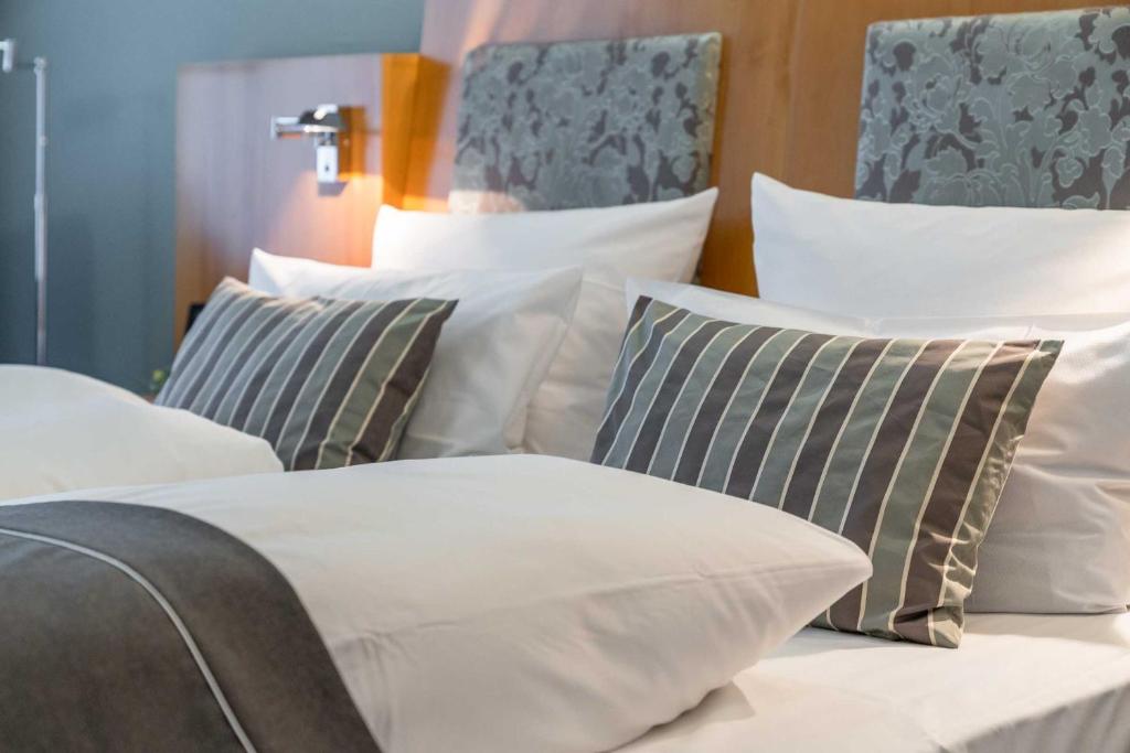 a group of white pillows on a bed at Residenz Hotel Detmold in Detmold