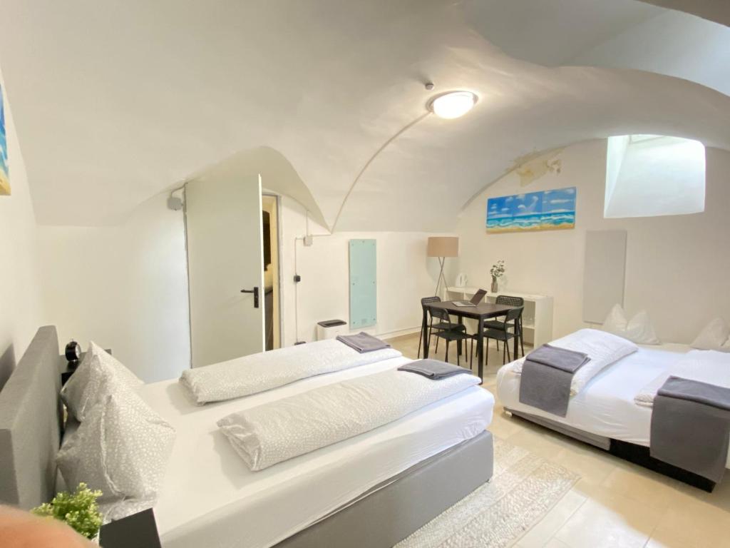 een slaapkamer met 2 bedden en een tafel. bij Cozy Flat near City Center - Souterrain - Limited Free Parking in Innsbruck