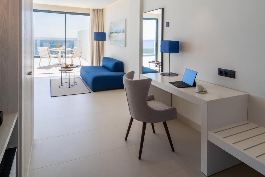 a room with a desk with a laptop and a chair at Royal Marina Suites Boutique Hotel - Adults Only in Puerto Calero