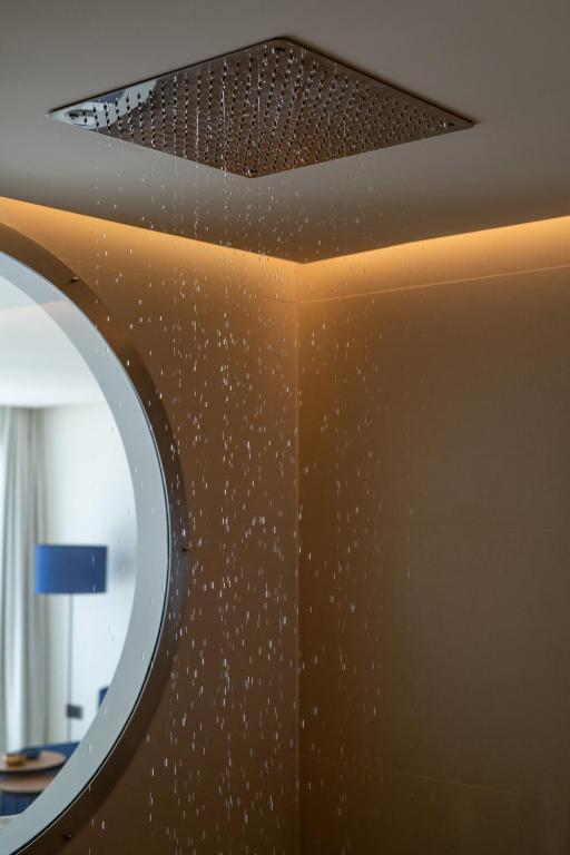 a room with a wall with a mirror and a ceiling at Royal Marina Suites Boutique Hotel - Adults Only in Puerto Calero