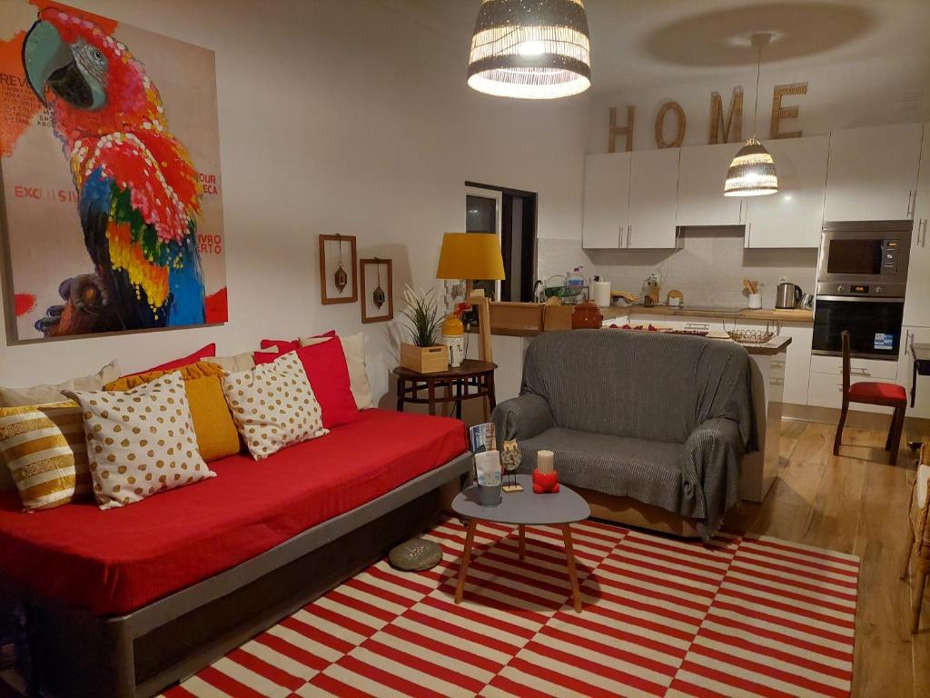 sala de estar con sofá rojo y silla en ELEVEN -A- SUITE tipo T1, en Mértola