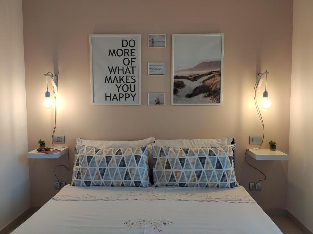 um quarto com uma cama com duas luzes na parede em DolceVita Home em Civitanova Marche