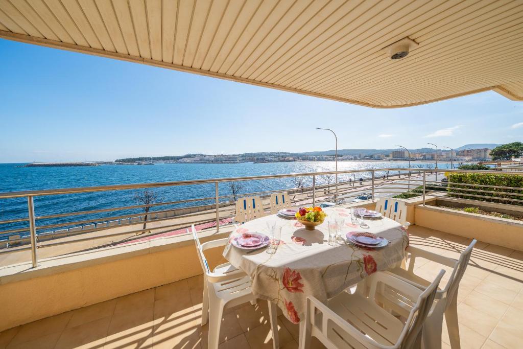 a table on a balcony with a view of the ocean at Apartament Greta in L'Escala