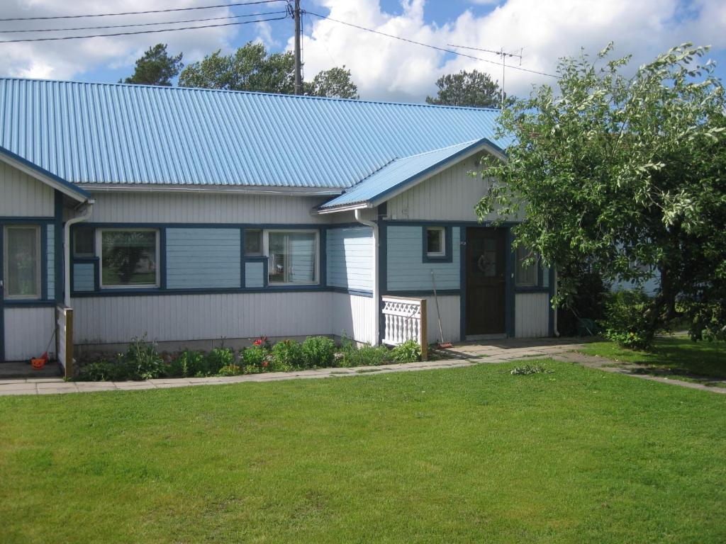 a house with a blue roof and a yard at Huoneistomajoitus Hella Härmä in Härmä