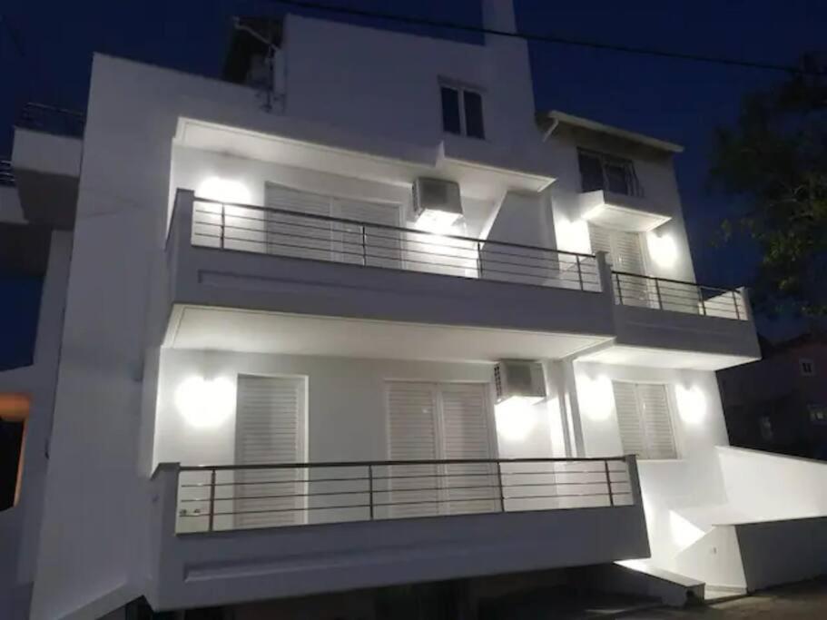 ein weißes Apartmenthaus mit Balkon in der Nacht in der Unterkunft Melinas in Káto Alissós