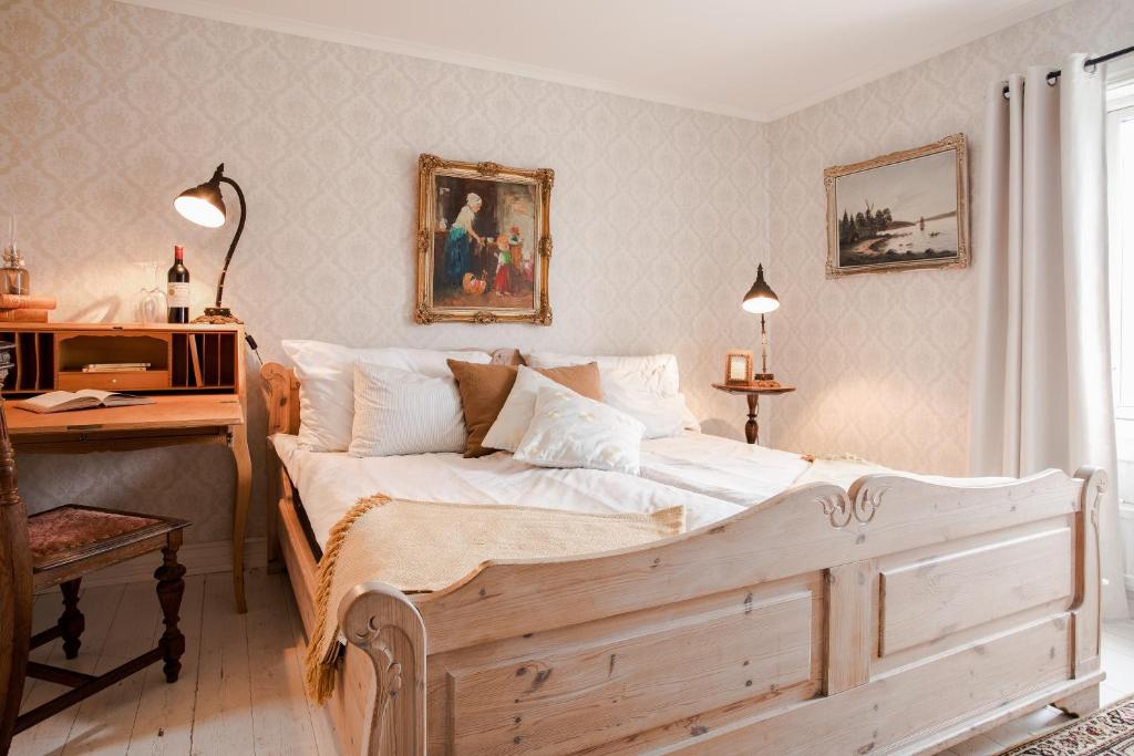 a bedroom with a wooden bed with a desk and a desk at Grand Hotel Lysekil in Lysekil