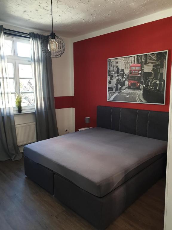 Un dormitorio con una cama y una pared roja. en Ferienwohnung Leonie, en Goslar