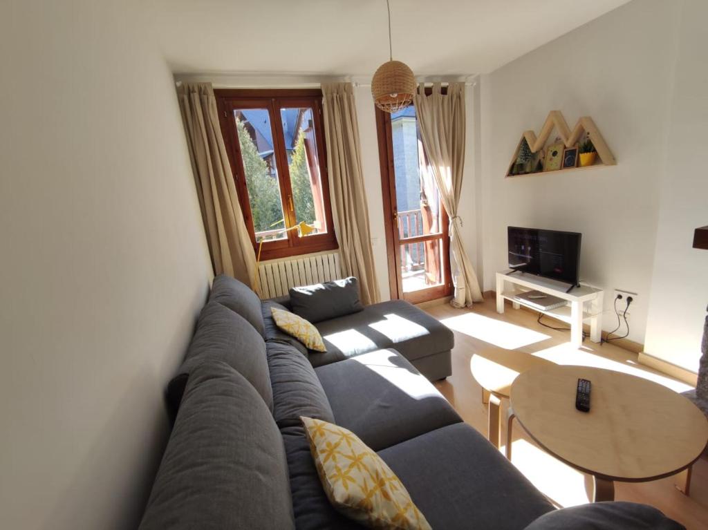 ein Wohnzimmer mit einem Sofa und einem Tisch in der Unterkunft Casa Cervino, La Coma de Alba-Benasque in Benasque