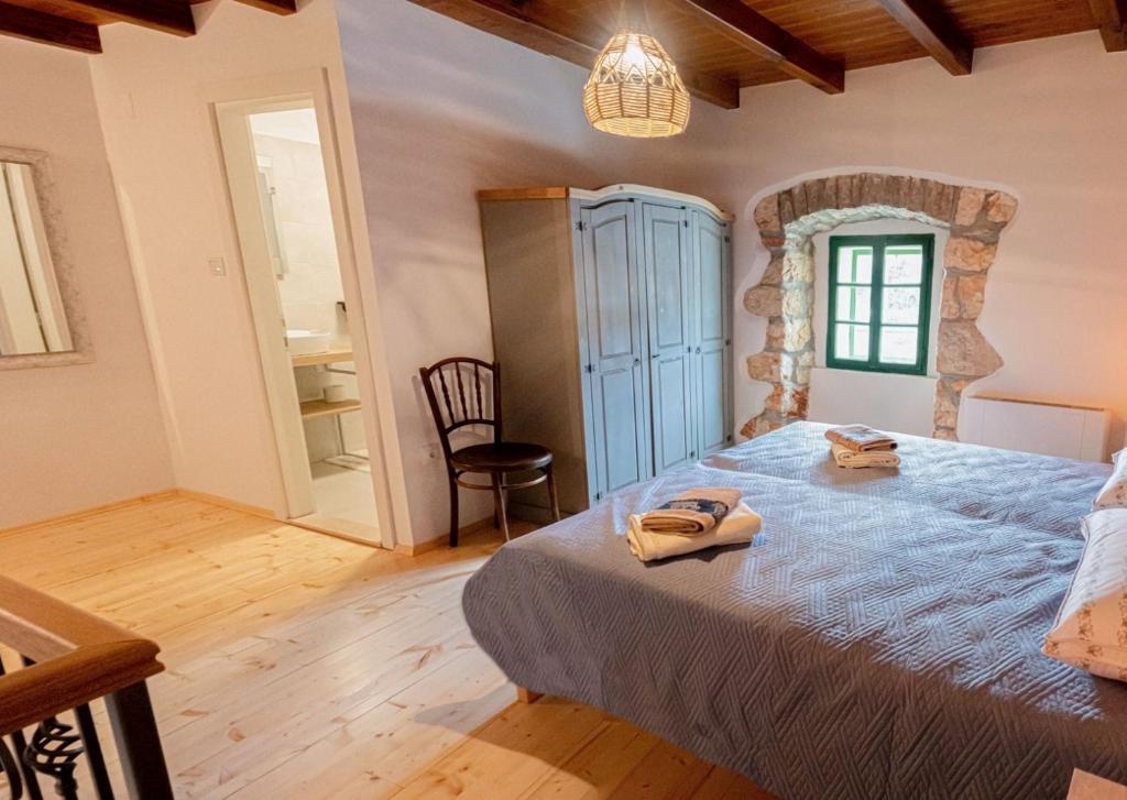 a bedroom with a large bed in a room at Holiday House Antica for 6 persons green surroundings of the island of Cres in Vidović