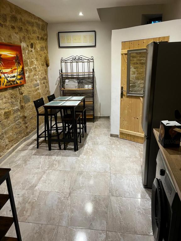 Un comedor con una mesa y un refrigerador. en APPARTEMENT CAROMB proche Mont VENTOUX avec clim, en Caromb