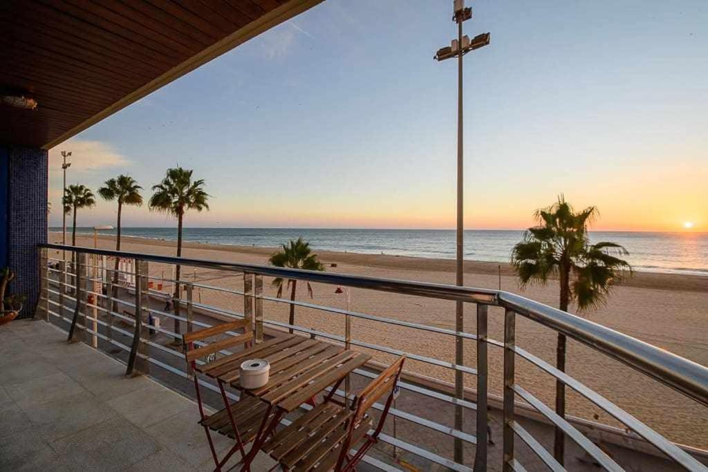 a table and chairs on a balcony overlooking the beach at Preciado apartamento con vistas frontales al mar in Cádiz