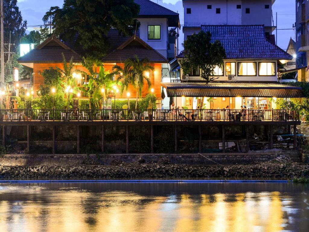 une maison à côté d'une rivière la nuit dans l'établissement Ban U Thong Accommodations, à Phra Nakhon Si Ayutthaya