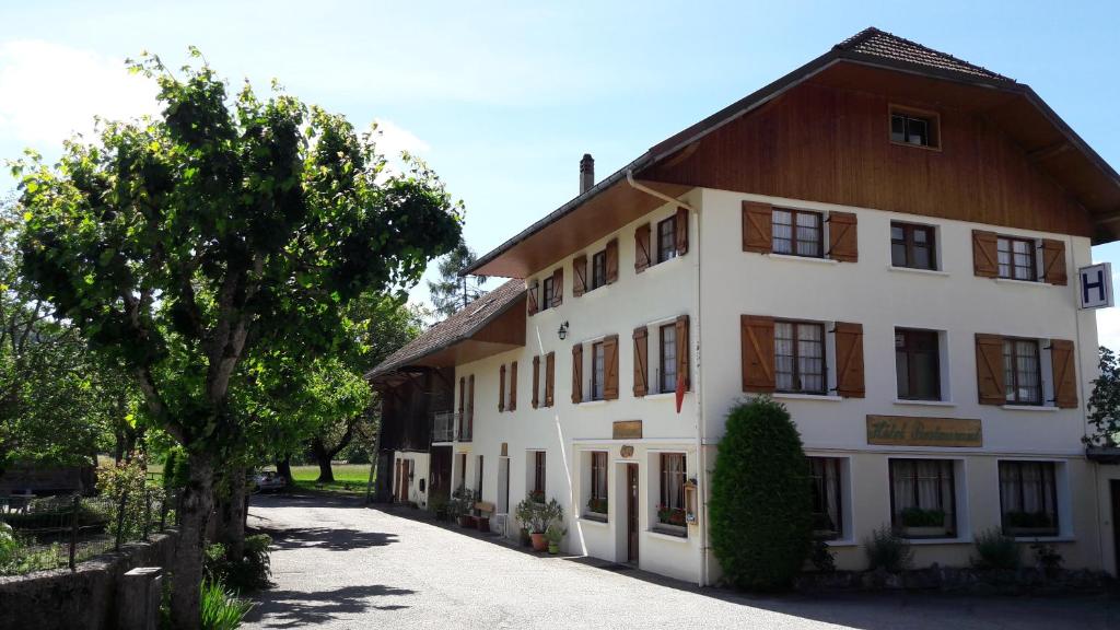 a large white building with a wooden roof at Hotel MAZIN in La Motte-en-Beauges