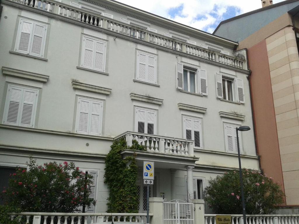 duży biały budynek z białymi okiennicami w obiekcie Villa Giulia w Grado