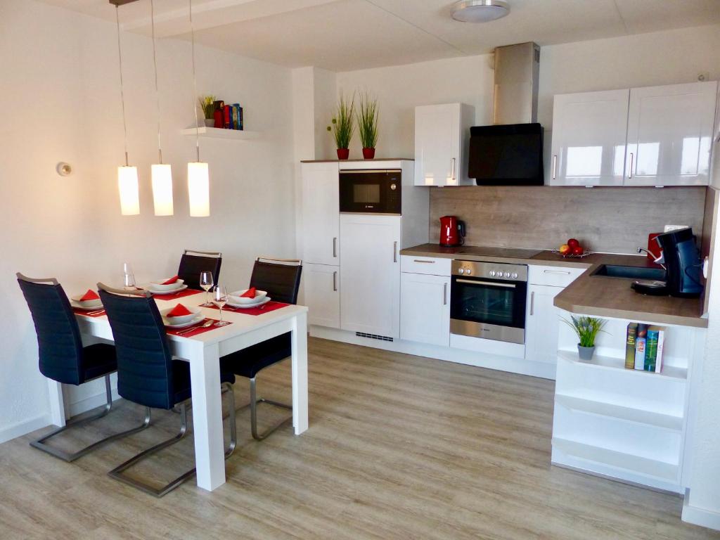 a kitchen and dining room with a white table and chairs at Petten Beach 17 in Petten