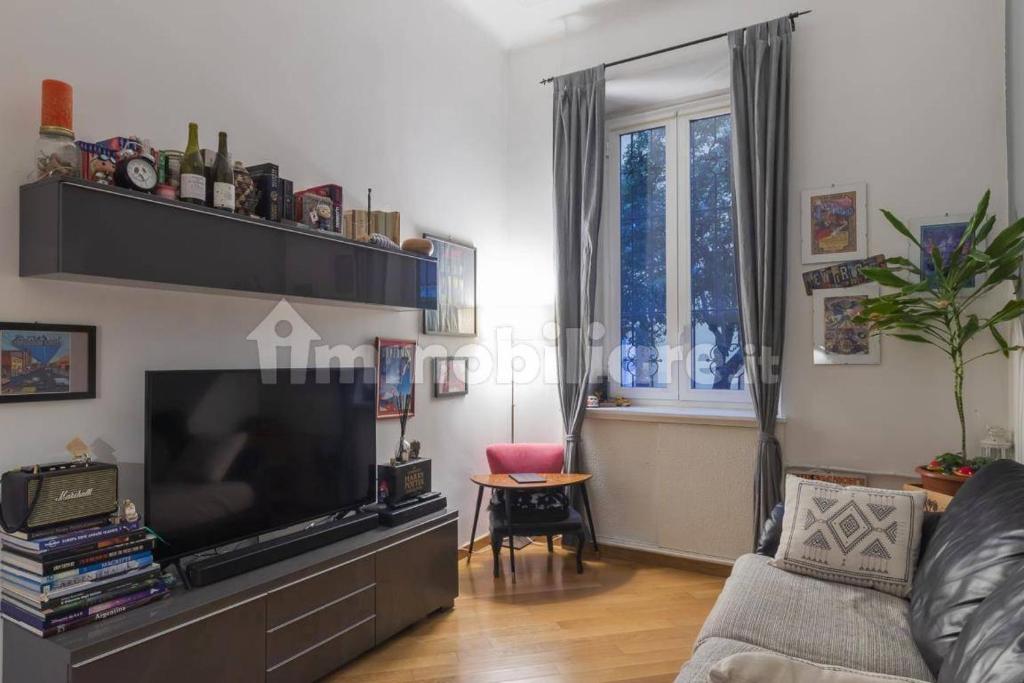 a living room with a couch and a television at Incantevole appartamento accanto fondazione Prada in Milan