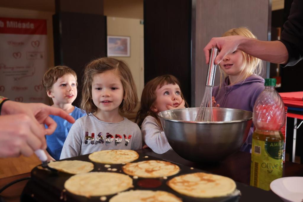a group of children standing around a table making pancakes at Hôtel Miléade L'Orangeraie - Menton in Menton