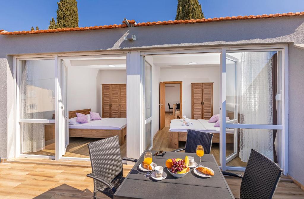 Zimmer mit einer Terrasse mit Tisch und Stühlen in der Unterkunft Apartments Sweet and Cozy in Cavtat