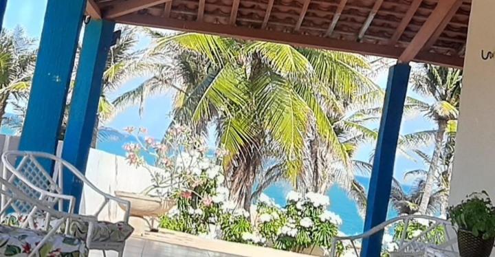 a palm tree on a balcony with a table and a chair at Vista pro mar maravilhosa,Tibau-RN in Tibau