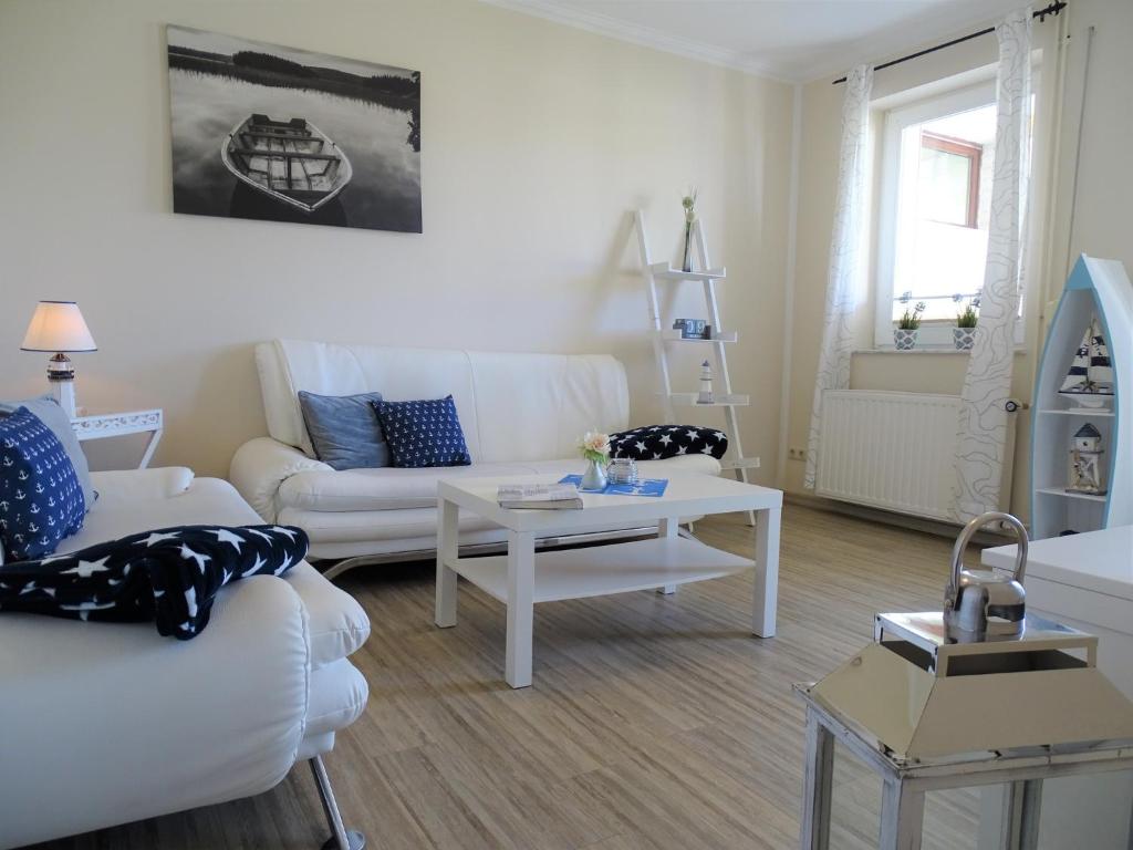 a living room with two white couches and a table at Scheitz 1 in Dahme