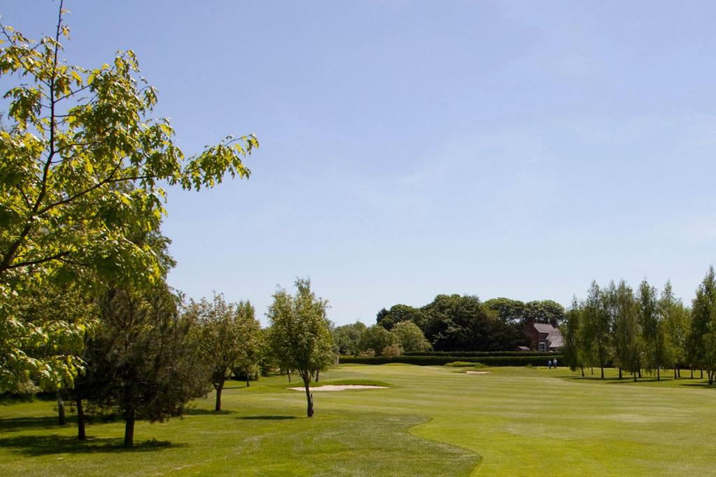 uma vista para um campo de golfe com árvores e um verde em Appletree Holiday Park em Boston