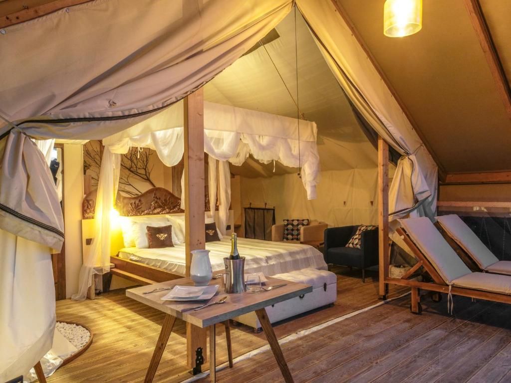 ザグレブにあるZaluka Urban Glampingのテント内のベッドルーム1室(天蓋付きベッド1台付)