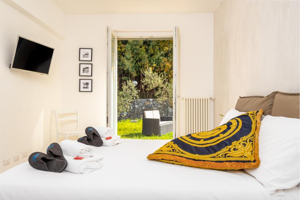 a white bed with a yellow and blue blanket on it at Appartamento Ercole in Sestri Levante