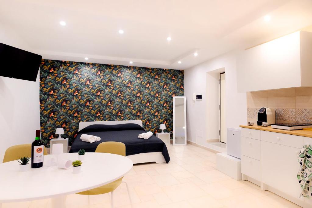 een slaapkamer met een bed en een tafel en een keuken bij LOGICO 56 in Bari