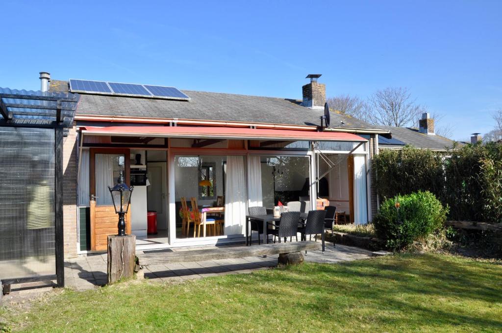 een huis met een veranda met een tafel en stoelen bij Boerenslag 10 in Sint Maartensvlotbrug