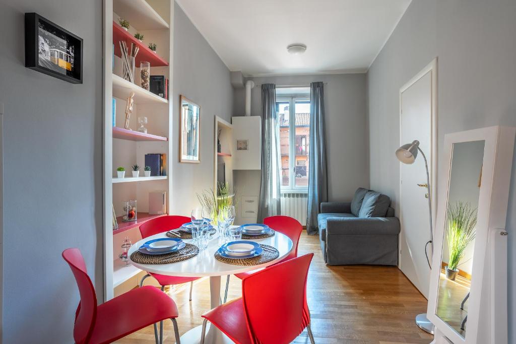 a living room with a table and red chairs at [NAVIGLI-DUOMO] Apartment with Netflix+Wifi in Milan