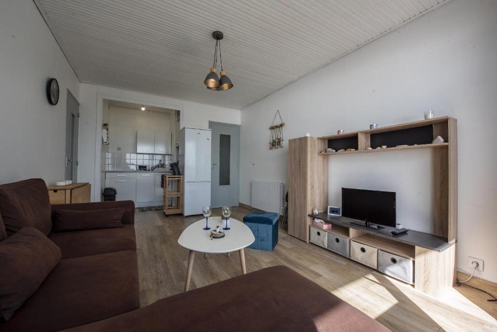 een woonkamer met een bank en een tv bij Venez profiter de ce bel appartement situe a Saint Hilaire de Riez in La Parée Preneau