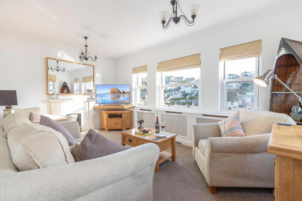 a living room with two couches and a tv at Apters Hill House in Brixham