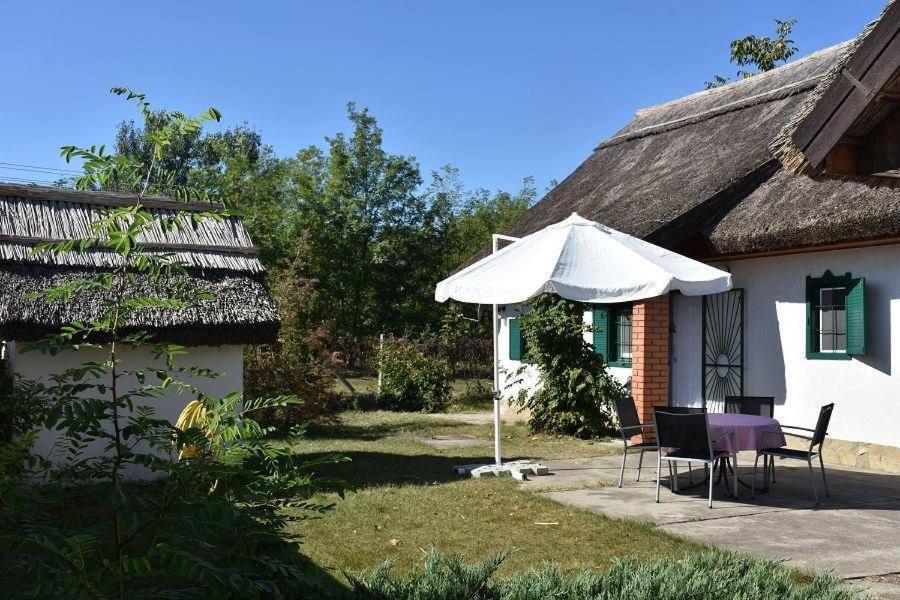 una casa con mesa, sillas y sombrilla en Boróka Tanya, en Orgovány