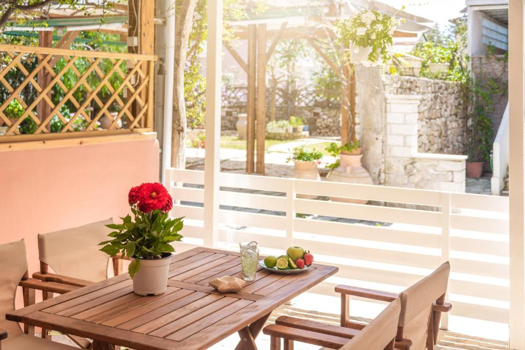 a wooden table with a bowl of fruit on a patio at Τrilogy Studios in Syvota