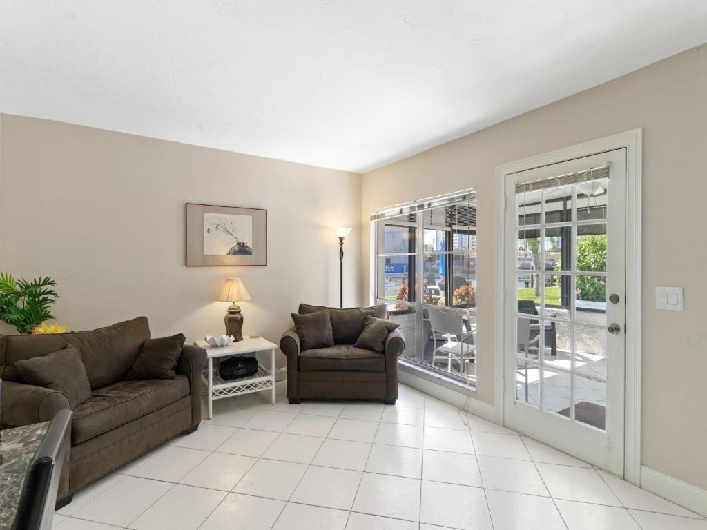 sala de estar con sofá y sillas y patio en 1 Bedroom at Madeira Beach Yacht Club 165C, en St Pete Beach
